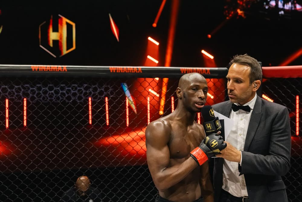 Thomas Desson interviewant un combattant dans la cage, Hexagone MMA